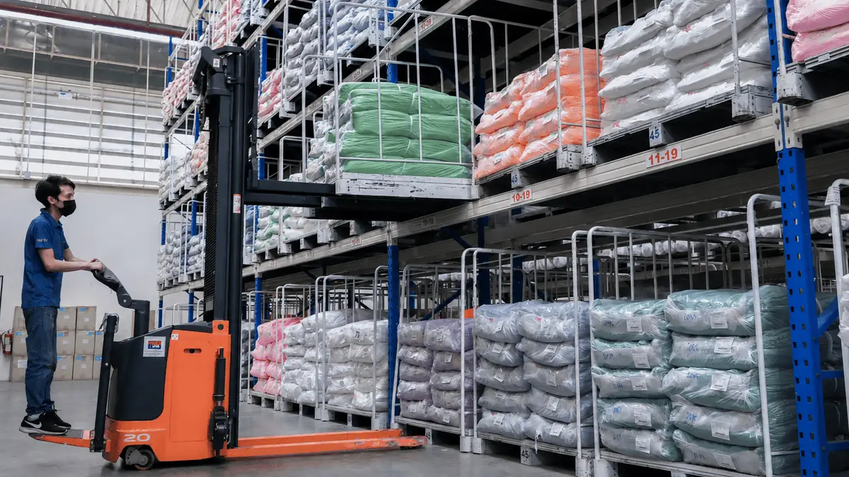 Forklift moving packaged fleece blankets in an organized blanket manufacturer warehouse in Thailand